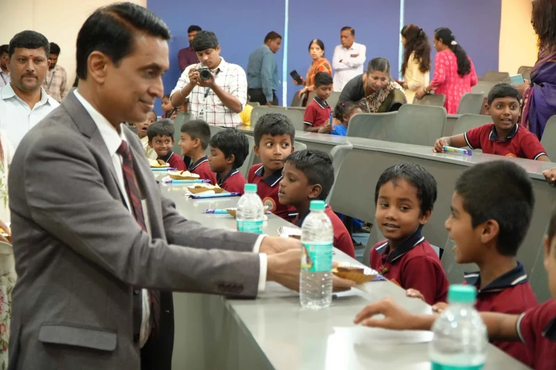 Dr. S.R. Sridhara Murthy distributing refreshments to students at Foundation Day 2026